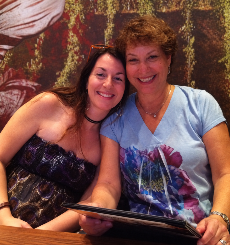 Wendi sitting closely with her mom and smiling while pregnant with AJ.