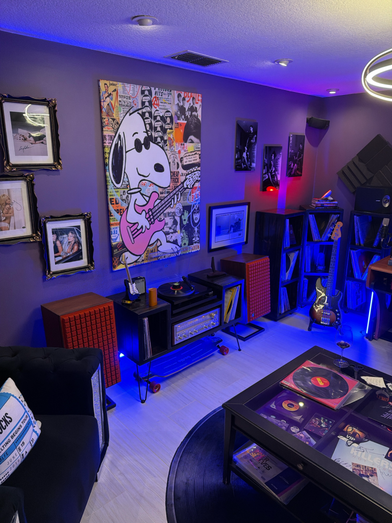 Wendi and Dan’s music room filled with vinyl records, guitars, music memorabilia, colorful lighting and a large Snoopy playing guitar artwork.