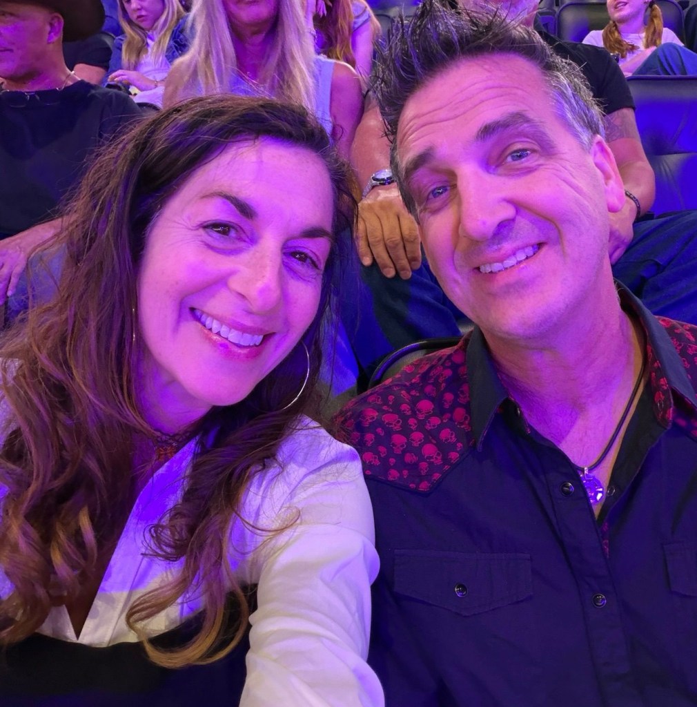 Wendi and Dan smiling together at a concert, one of many live music experiences they have shared.