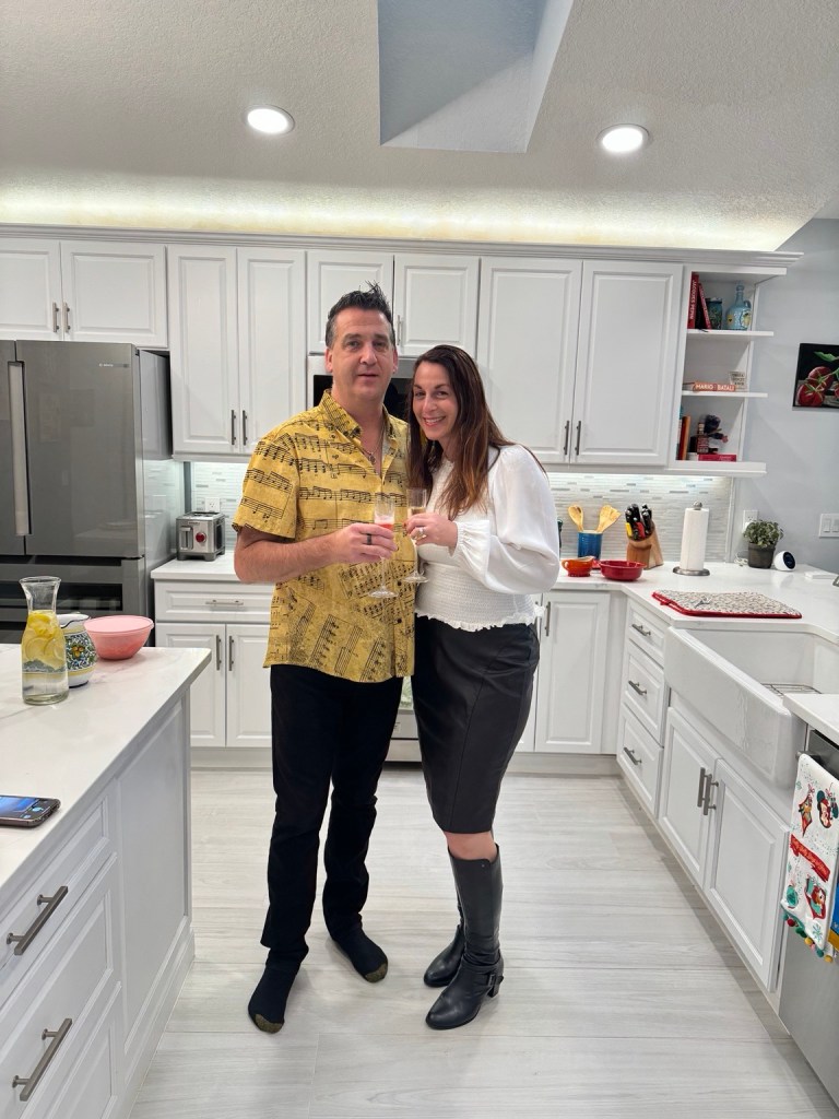 Wendi and Dan standing together in their kitchen beside the large center island.